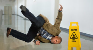 A man slips and falls on a wet floor in an office building