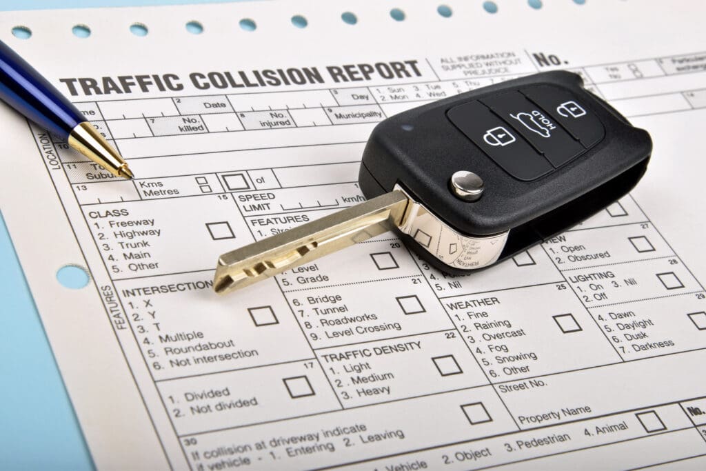 Car accident report paperwork with car keyfob